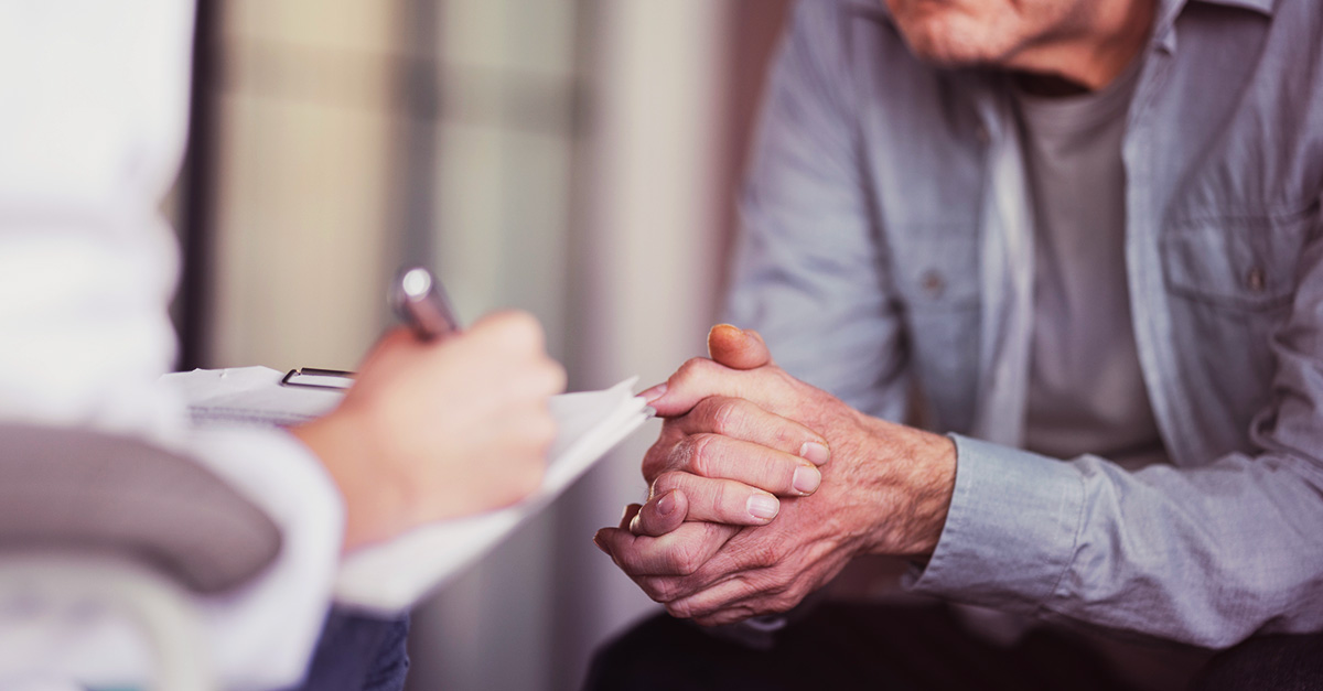 kvinna med skrivblock pratar med äldre man